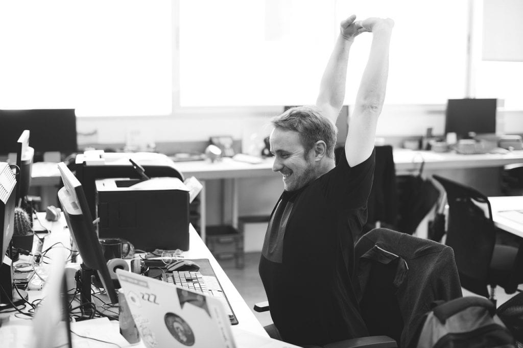 Man stretching at his desk