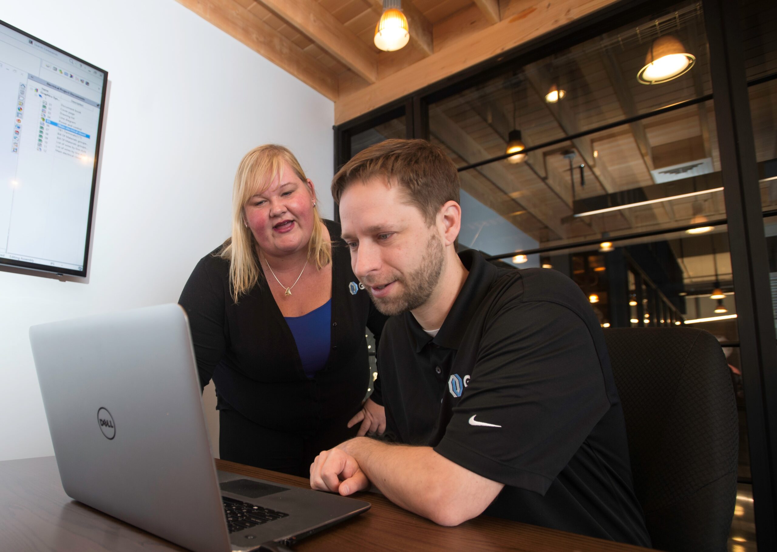 Two staff hovering over a computer