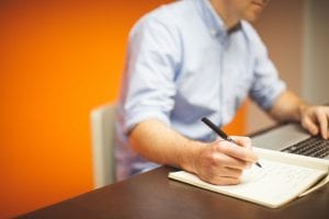 Worker writing out notes by hand