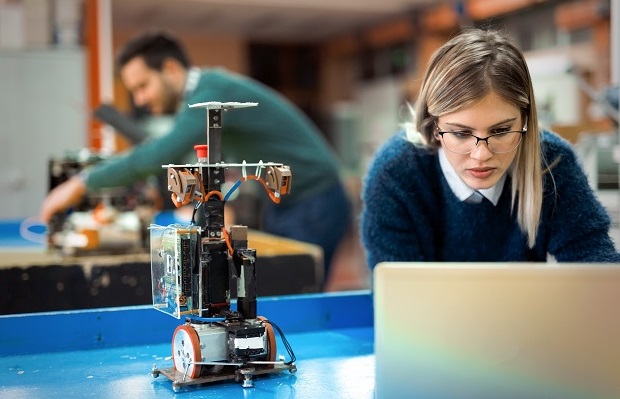 Woman hovering over laptop working on electrical project