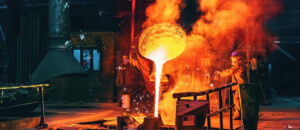 Liquid iron molten metal pouring in container, industrial metallurgical factory, foundry cast, heavy industry background