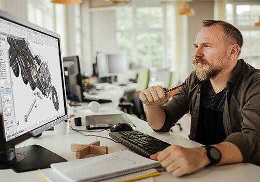 Worker studying a project on computer screens